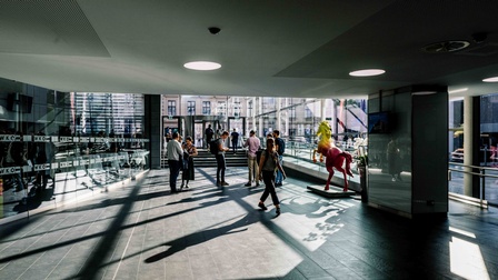 Eingangsbereich der Wirtschaftskammer Österreich mit Menschen, die ein und aus gehen