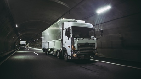 Weiße LKWs fahren durch einen Tunnel