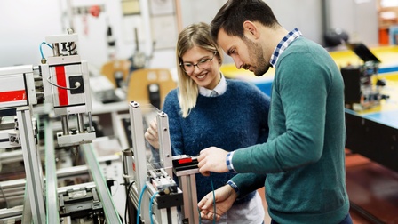 Personen arbeiten gemeinsam an einem Mechatronik-Werkstück