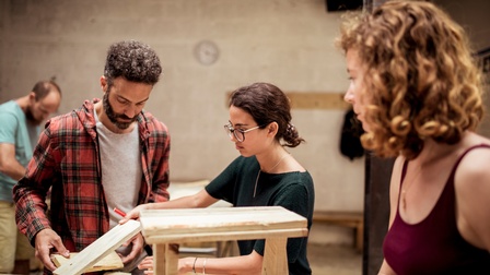 Personen verarbeiten Holz in einer Werkstatt 