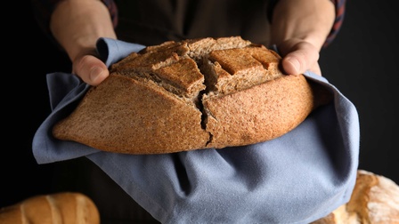 Eine Person hält einen Laib Brot in beiden Händen