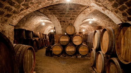 Gewölbekeller voller neben- und aufeinandergestapelter Holzfässer