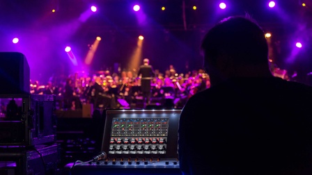 Veranstaltungstechniker am Mischpult während einer Konzertaufführung