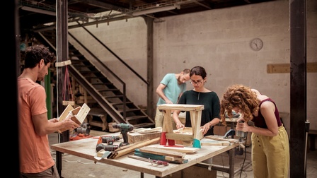 Personen verarbeiten Holz in einer Werkstatt