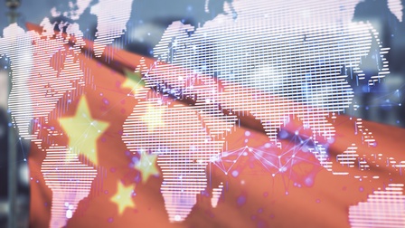 Im Vordergrund ist eine Grafik der verschiedenen Kontinente der Erde. Dahinter ist die chinesische Flagge