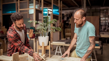 Personen verarbeiten Holz in einer Werkstatt 