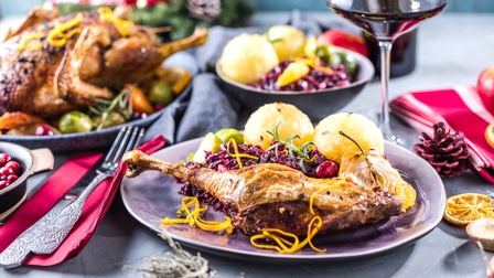Dekorierter Tisch mit knusprig gebratener Weihnachtsgans und Beilagen