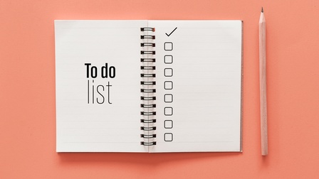 Aufgeklappter Spiralblock mit Schriftzug To do list und Checkboxen, daneben Bleistift liegend, Hintergrund lachsfarben