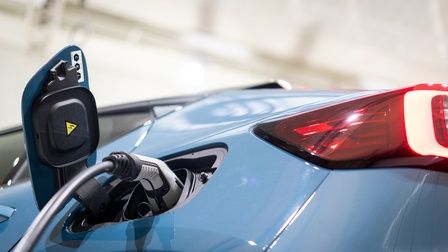 Fokus auf das Heck inklusive Ladestecker eines ladenden Elektroautos