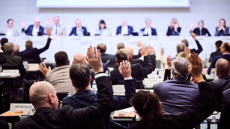 2. Sitzung des Wirtschaftsparlamentes am 27. November 2025: Mehrere sitzende Personen in einem Saal in Rückenansicht, einige heben die Hand