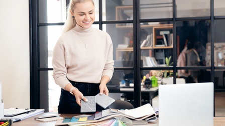 Eine Einrichtungsberaterin bei der Planung mit Stoff- und Farbmustern