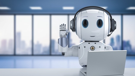 3D-Rendering eines Roboters mit Kopfhörern, der an einem Schreibtisch sitzt, winkt und vor sich einen Laptop hat