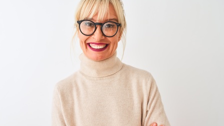 Porträt einer lächelnden Person mit Brillen mit verschränkten Armen