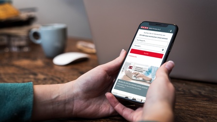 Smartphone mit Firmen-A-Z am Bildschirm