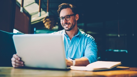 Person sitzt vor Laptop und arbeitet
