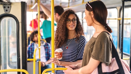 Personen mit Brille unterhalten sich einem öffentlichen Verkehrsmittel