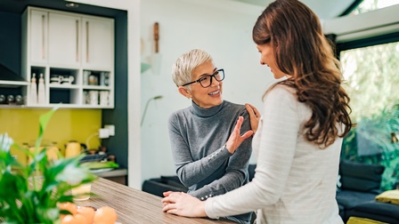 Personen unterhalten sich in einer hellen modernen Küche