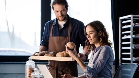 Personen betrachten Backwaren und kontrollieren Qualität