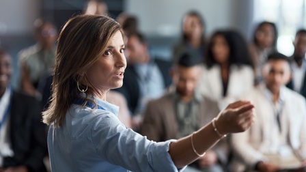 Vortragende in hellblauer Bluse bei Seminar