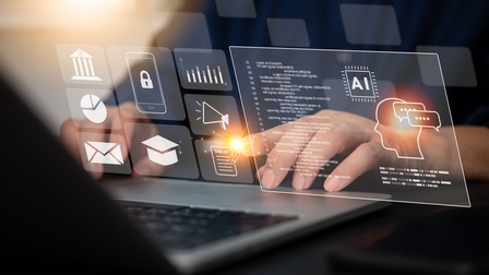 Nahaufnahme eines aufgeklappten Laptops mit grafischen Programmiericons.