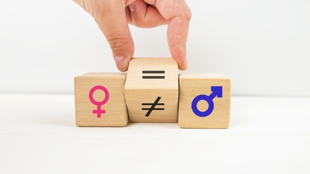 Vor hellem Hintergrund sind drei Würfel. Auf dem ersten ist das Symbol für Frauen, auf dem dritten das für Männer. In der Mitte ist ein Würfel auf dem ein Istgleichzeichen und ein durchgestrichenes Istgleichzeiten sind