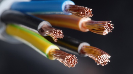 Fünf angeschnittene elektrische Leitungen vor einem dunklen Hintergrund. An den Enden ist die jeweilige Isolierung entfernt, sodass zahlreiche feine Kupferdrähte freiliegen