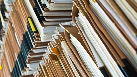 Drei sehr hohe Aktenstapel nebeneinander