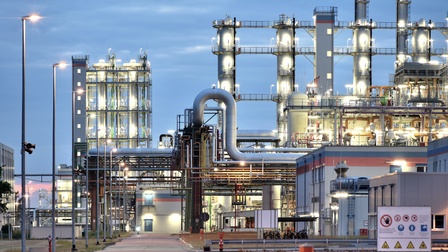 Beleuchtete Raffinerie in Dämmerlicht