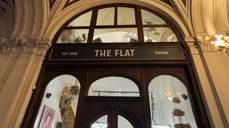Über einer Eingangstür eines Geschäfts steht The Flat, Wien seit 2018