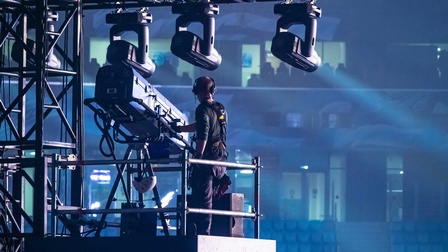 Ein Beleuchter bedient einen Scheinwerfer auf der Bühne