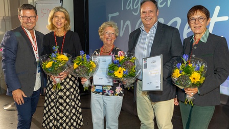 5 Menschen beim Tag der Energetik mit Blumen und Urkunden