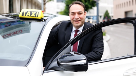 Obmann der Wiener Taxi-Innung neben Taxi auf der Straße