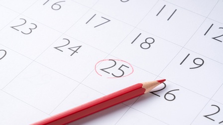 Kalendertag auf einem Kalenderblatt mit rotem Stift eingekreist, Stift liegt daneben