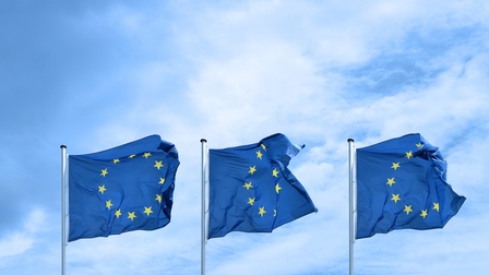 Drei EU-Flaggen flattern im Wind nebeneinander