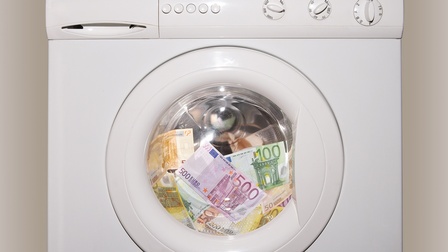 In einer Waschmaschinentrommel sind mehrere Euroscheine in unterschiedlichen Beträgen wie hundert, fünfzig, zweihundert oder fünfhundert.