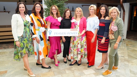 Eine Gruppe Frauen steht lächelt in die Kamera - in der Hand tragen sie einen Banner mit der Aufschrift 