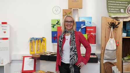 Person posiert vor einer Wand mit Geschenken 