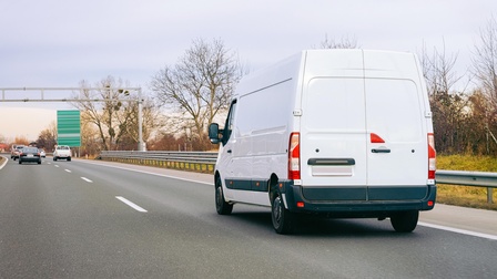 Weißer Transporter fährt auf einer Autobahn