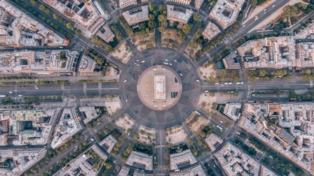 Top-Shot einer Stadtlandschaft mit einer Verkehrsinsel in der Mitte und davon sternförmig wegführend Straßen und Häuserblöcke
