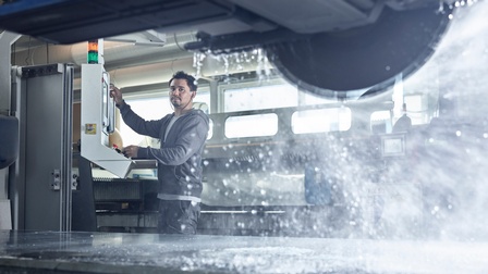 Ein junger Mann steuert eine Steinsäge