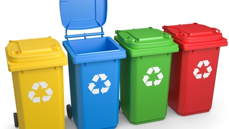 Illustration von vier verschiedenfarbigen Mülltonnen in gelb, blau, grün und rot mit Recyclingzeichen an den Vorderseiten - drei im Kreis verlaufende weiße Pfeile; die blaue Mülltonne hat den Deckel geöffnet, allesamt auf weißem Hintergrund
