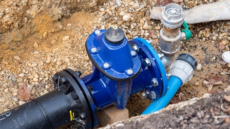 In einem Loch in der Erde liegt ein breites Rohr auf dem Boden