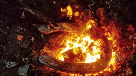 Ein Hufeisen in der Glut beim Schmieden