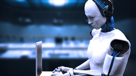 Weißer lächelnder Roboter auf Laptop blickend und darauf tippend