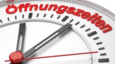 Nahaufnahme einer Uhr mit Titel Öffnungszeiten