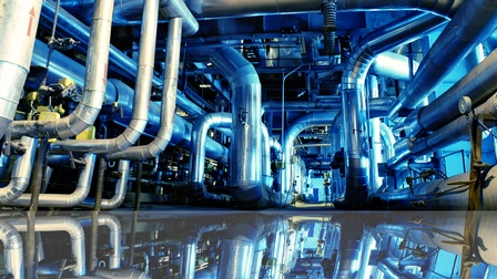 Industriezone mit Stahlrohren mit blauen Lichtreflexionen am Boden