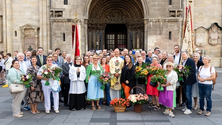 Menschengruppe mit Blumen vor Tor des Stephansdoms