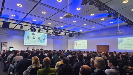 Personen in einem Vortragsaal im Zuge der Veranstaltung STROM DAYS von Startup-Now. Die Personen sitzen auf Sesseln, man sieht außerdem einen Bildschirm mit einer Präsentation. 