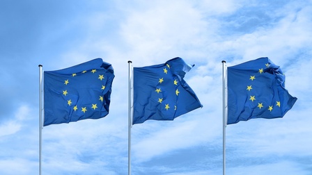 Drei EU-Flaggen flattern im Wind nebeneinander