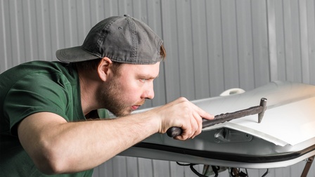 Dellentechniker bei der Reparatur von Beulen in einer Autotür